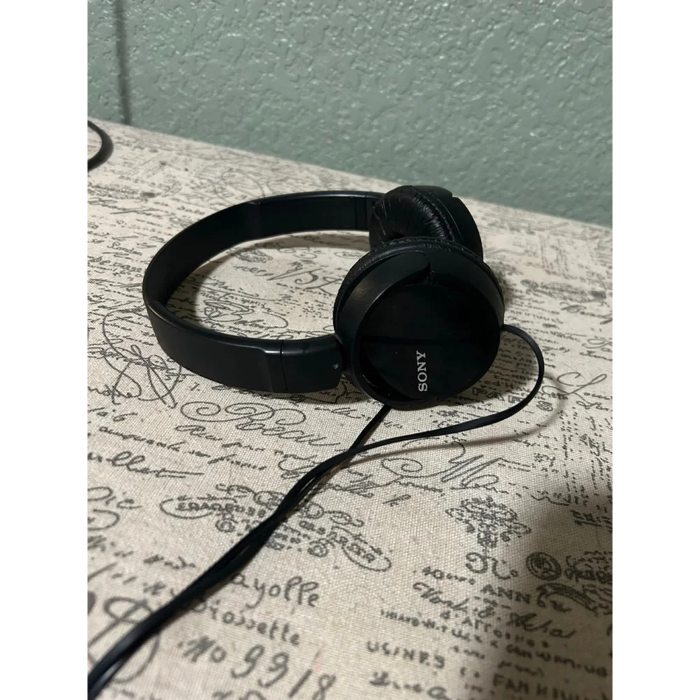 These are a pair of black Sony on-ear wired headphones. The earcups feature the